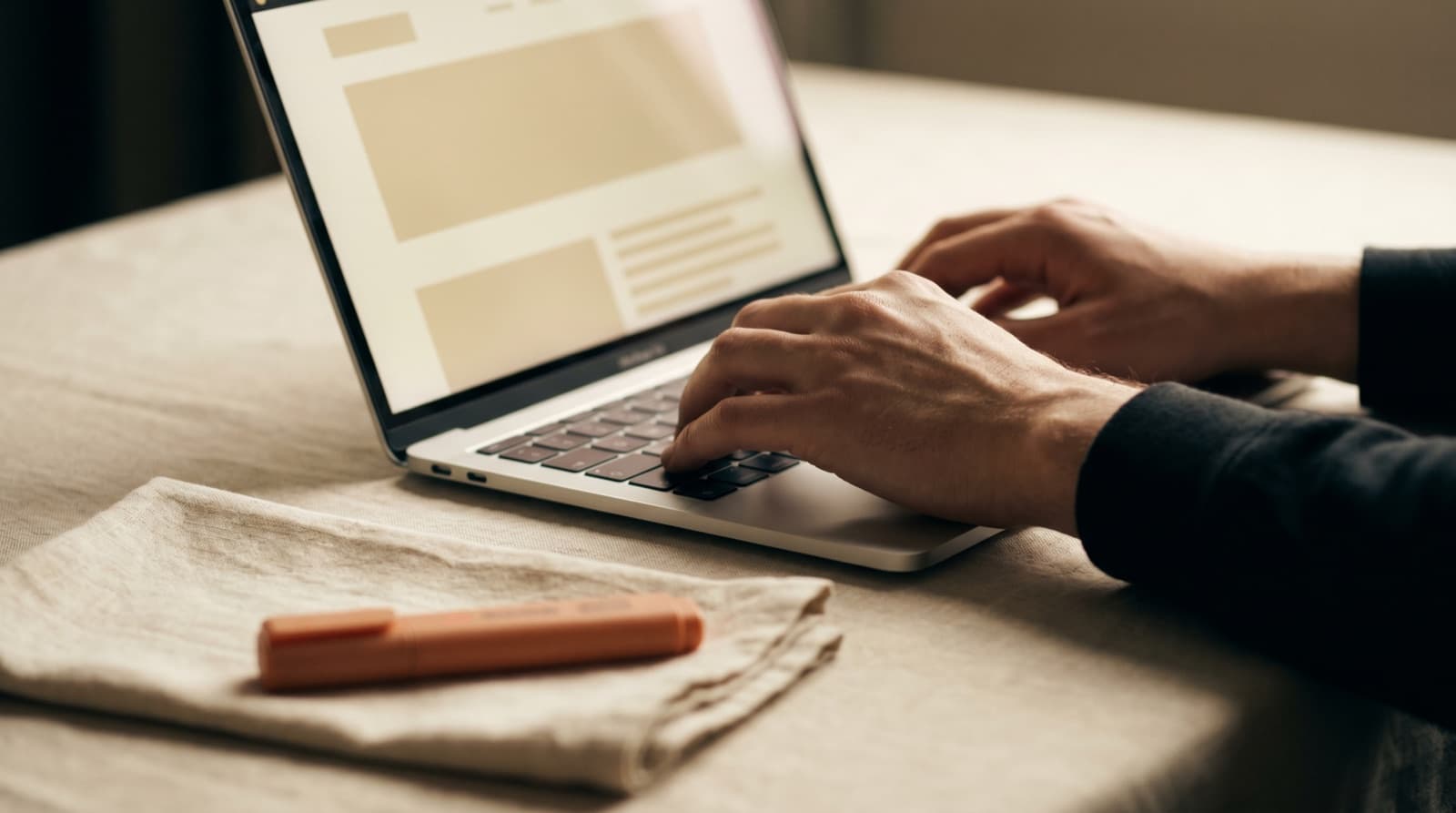 Handen typen op een laptop met een websitelayout op het scherm